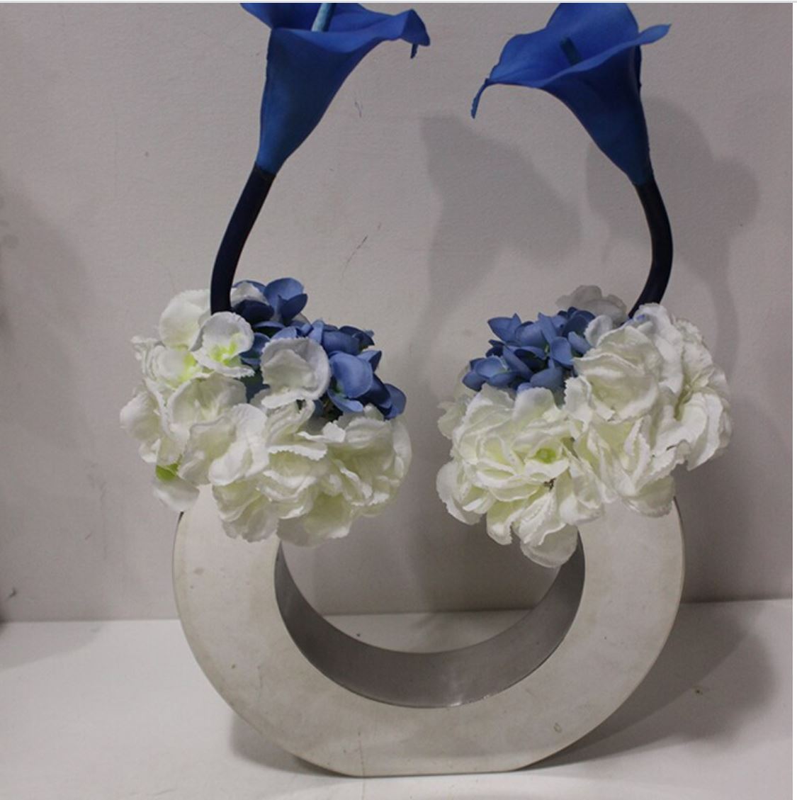 a white and blue flower arrangement in a circular vase