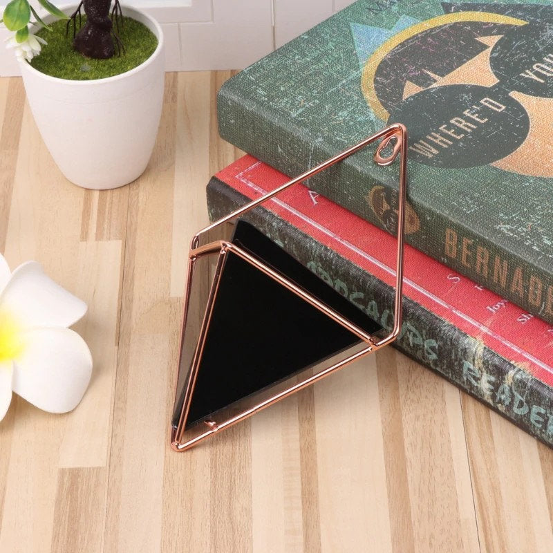 a triangle shaped object sitting on top of a stack of books