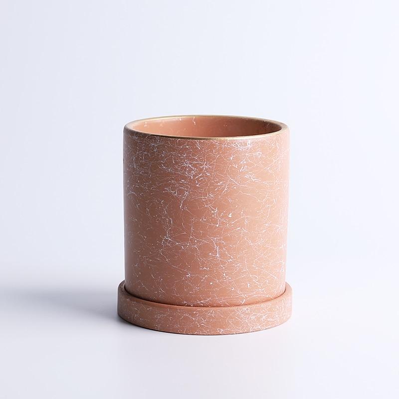 a pink vase sitting on top of a white table