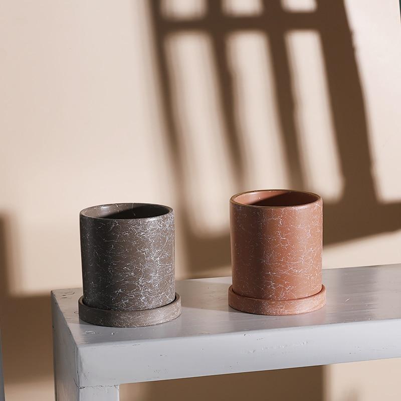 two vases sitting on top of a white table