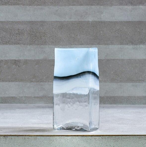 a glass vase sitting on top of a table